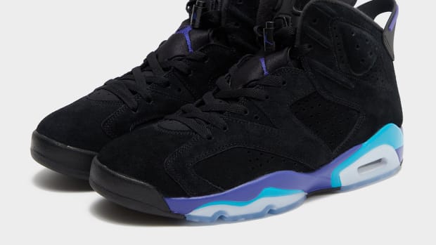 Side view of black, purple, and aqua Air Jordan sneakers.